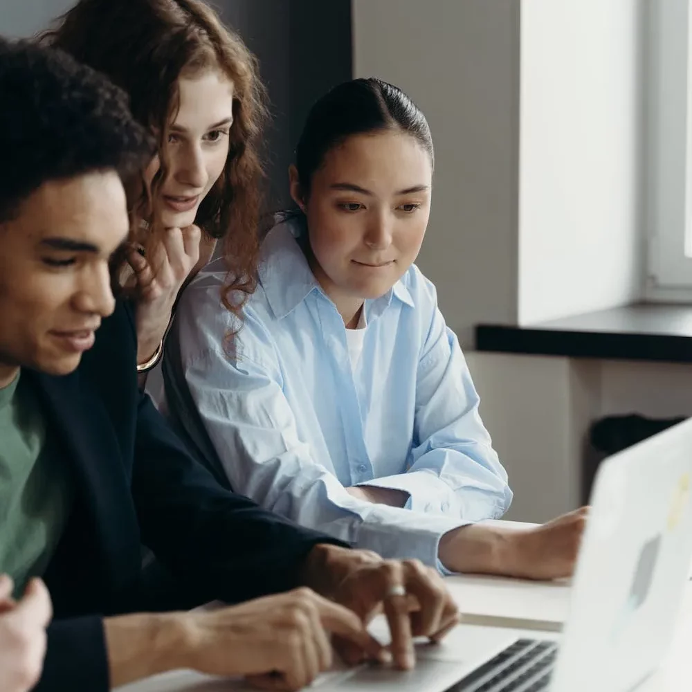 three people collaborating at laptop